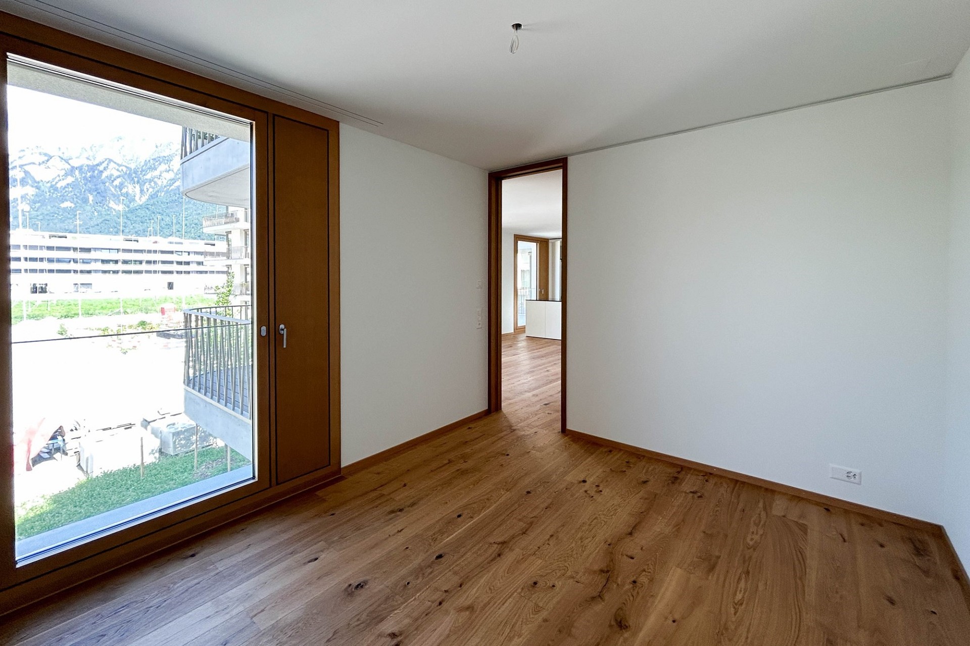 Heller Wohnraum mit Balkon- und Bergblick