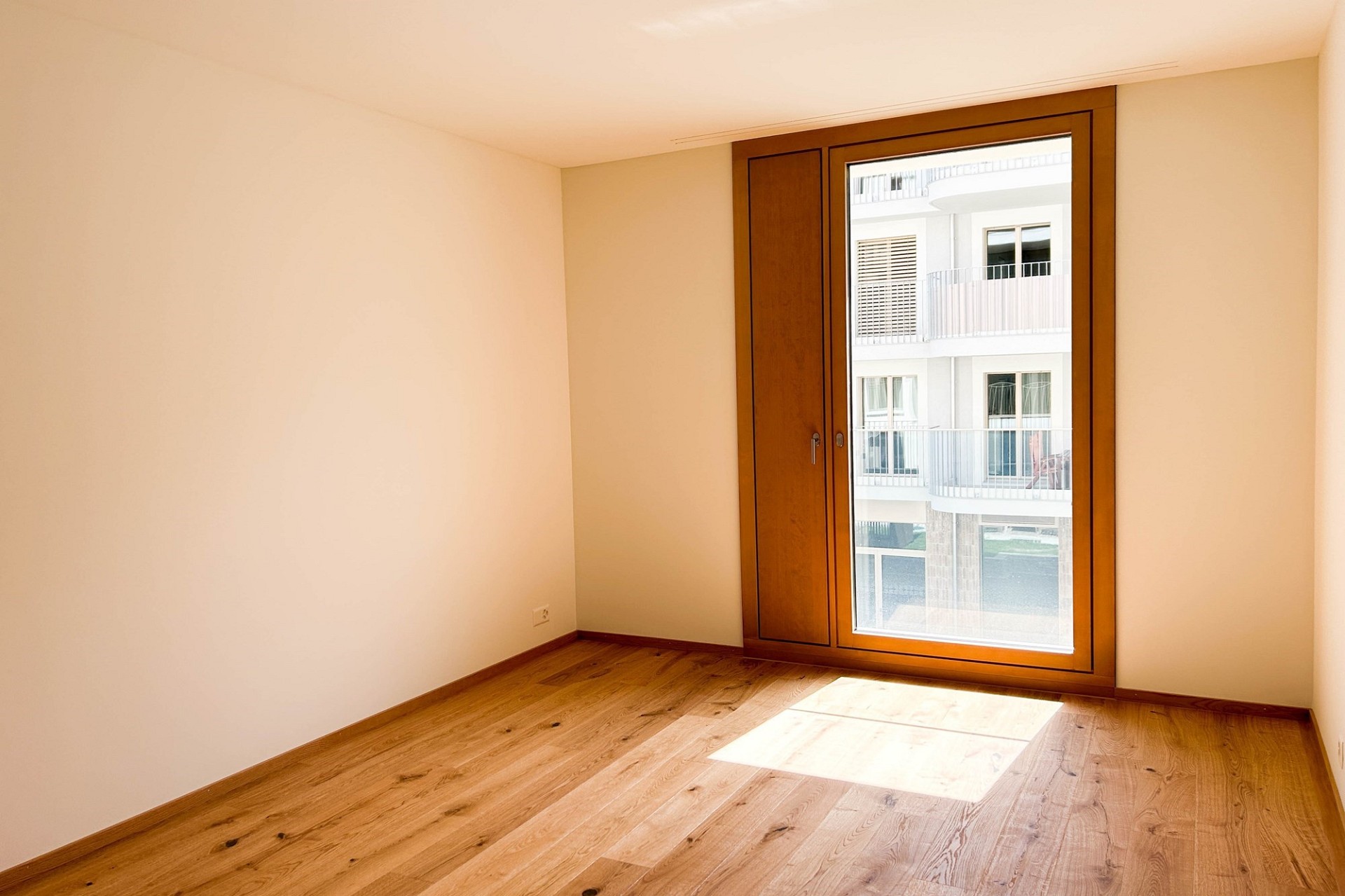 Heller leerer Raum mit großem Holzfenster