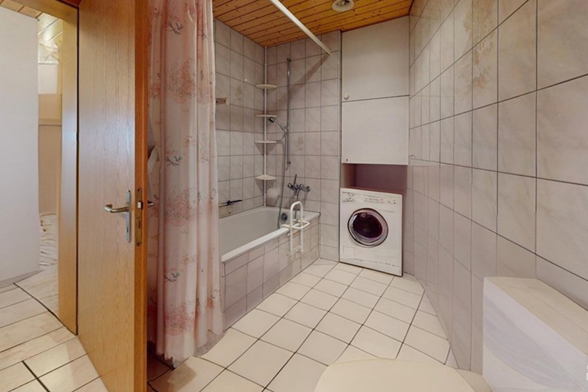 Badezimmer mit Badewanne und Waschmaschine