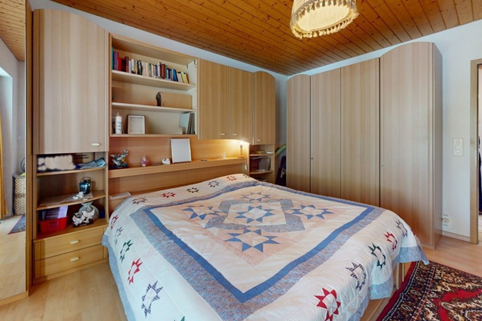 Gemütliches Schlafzimmer mit Holzdecken und Einbauschränken