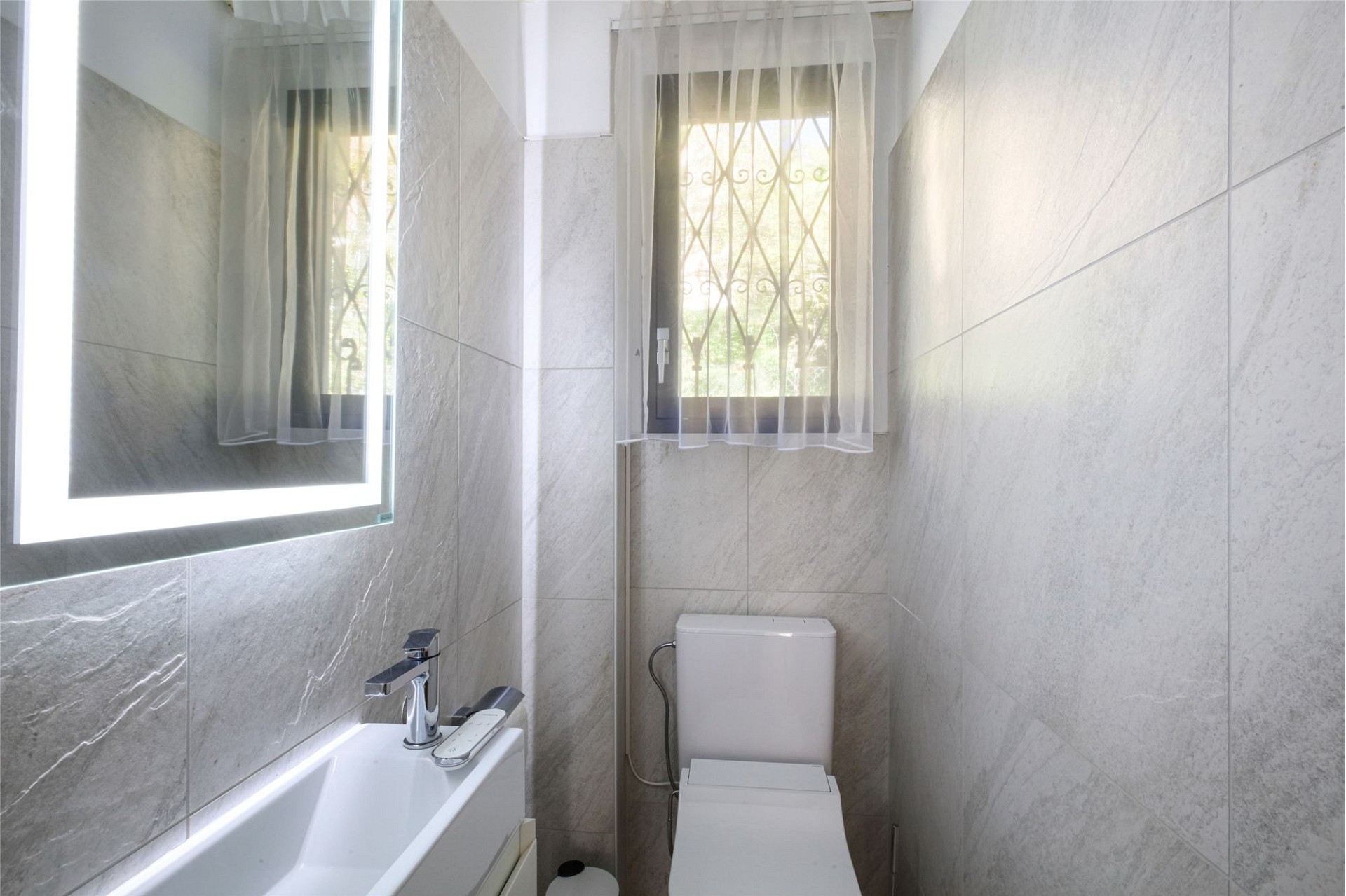 Gäste-WC mit Fenster und Wandfliesen