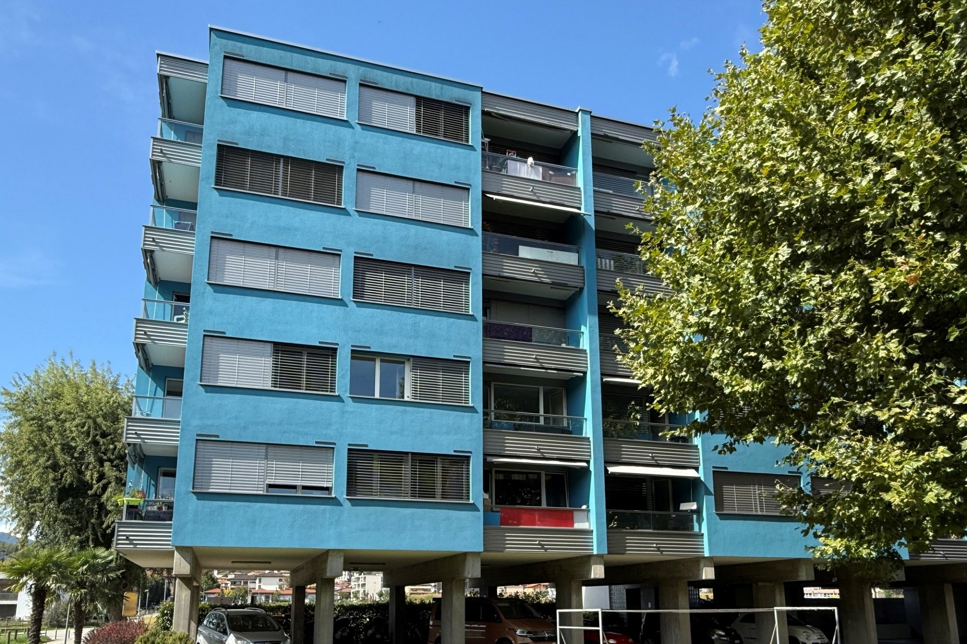 Mehrfamilienhaus mit blauer Fassade und Balkonen