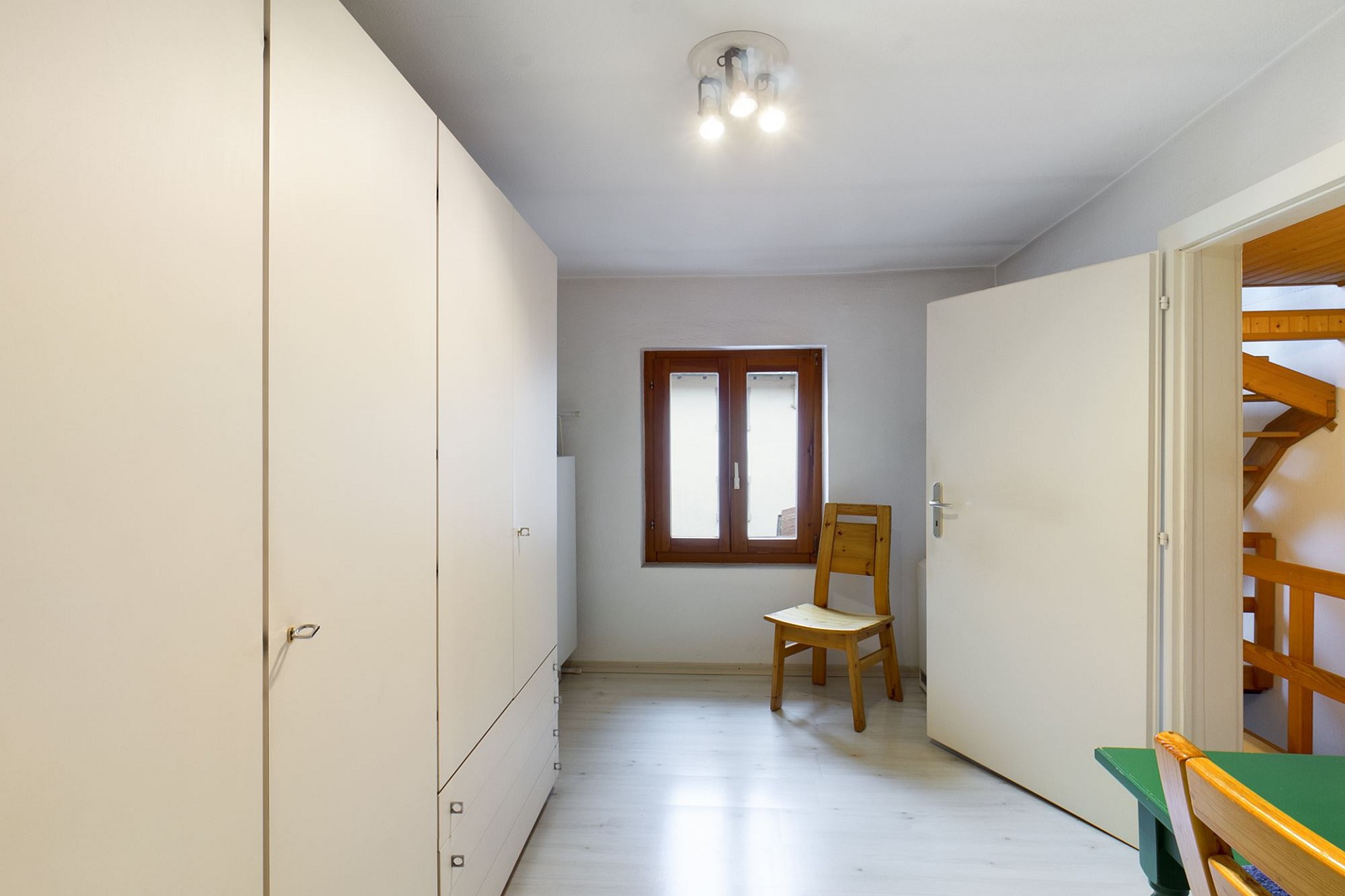 Helles Zimmer mit Einbauschränken und Fenster