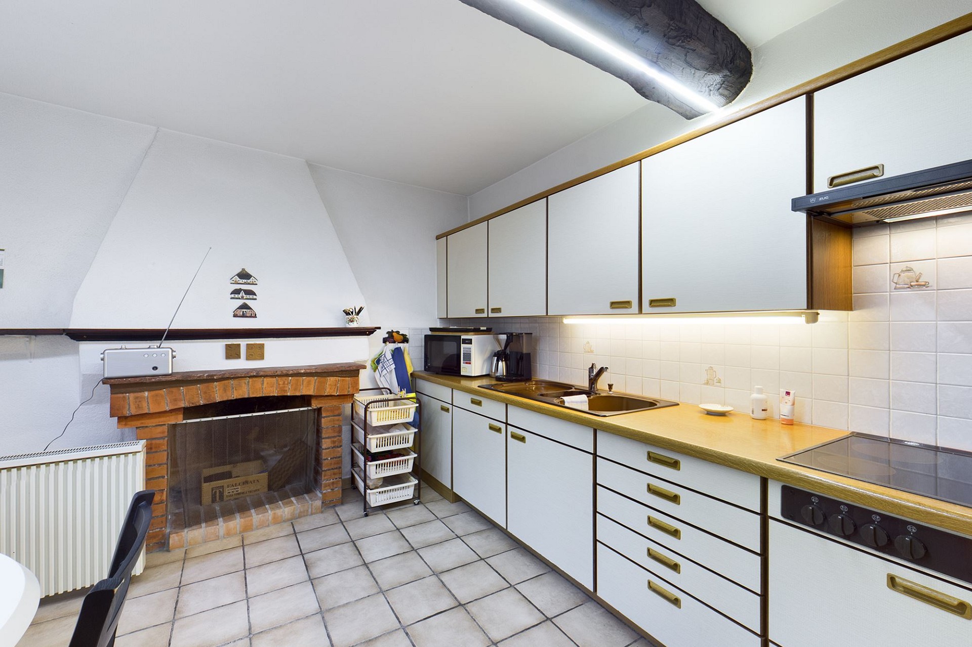 Kleine Küche mit Kamin und Einbauküche