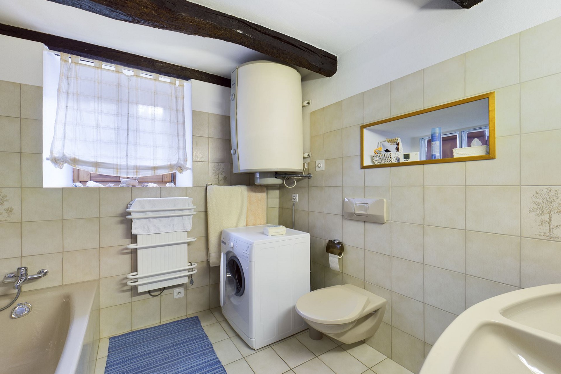 Kleines Badezimmer mit Waschmaschine und Badewanne