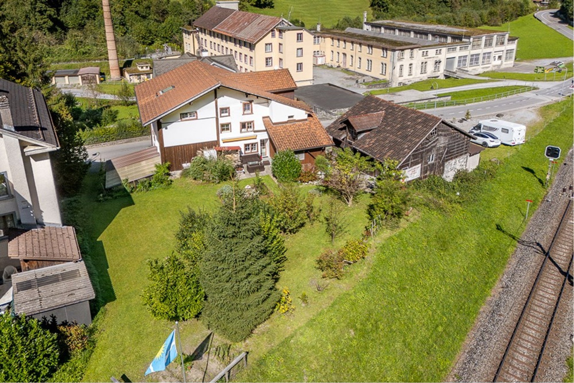 Luftaufnahme eines ländlichen Anwesens mit Garten und Nebengebäuden