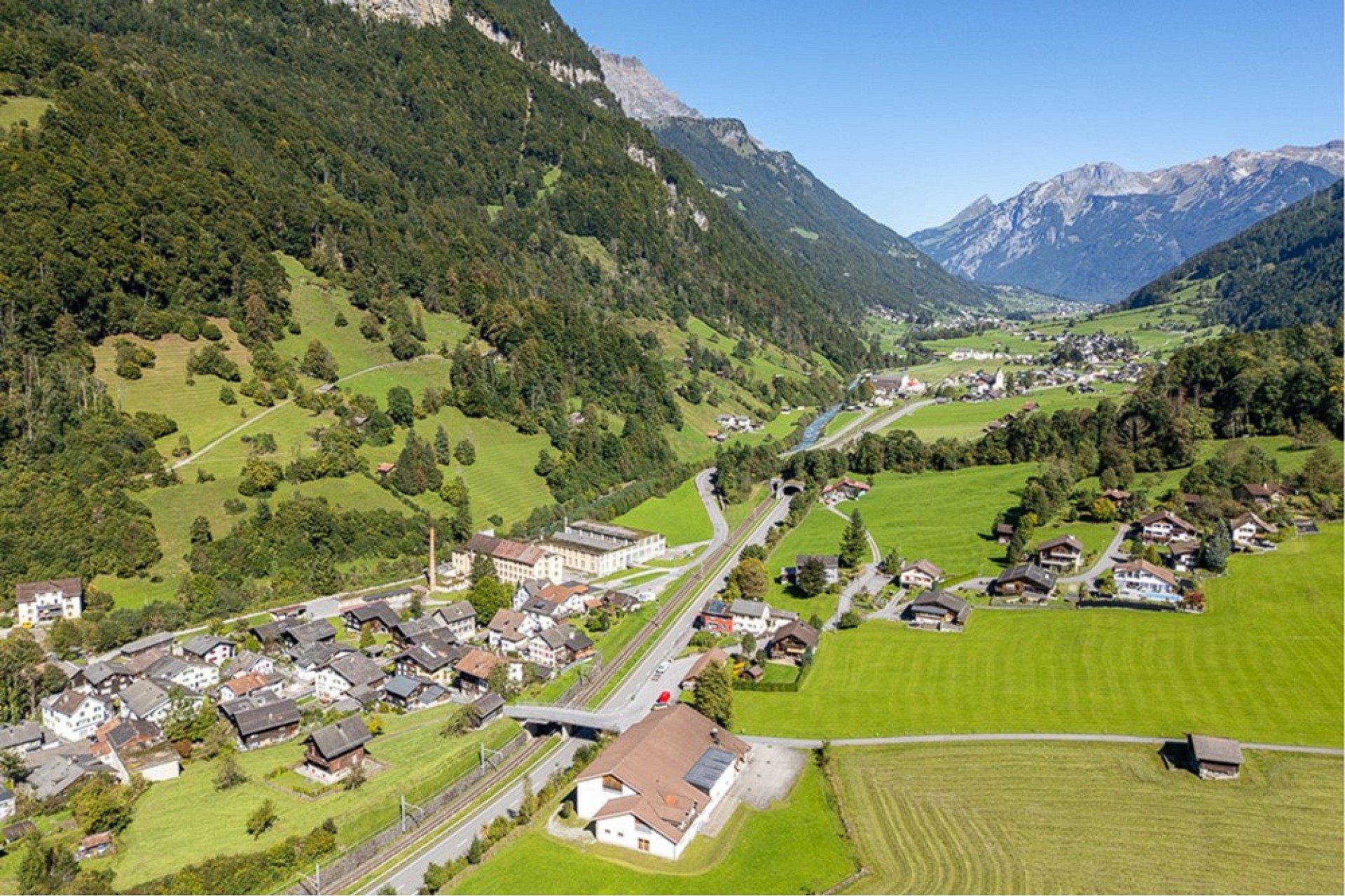 Alpenlandschaft mit Talort aus der Luft