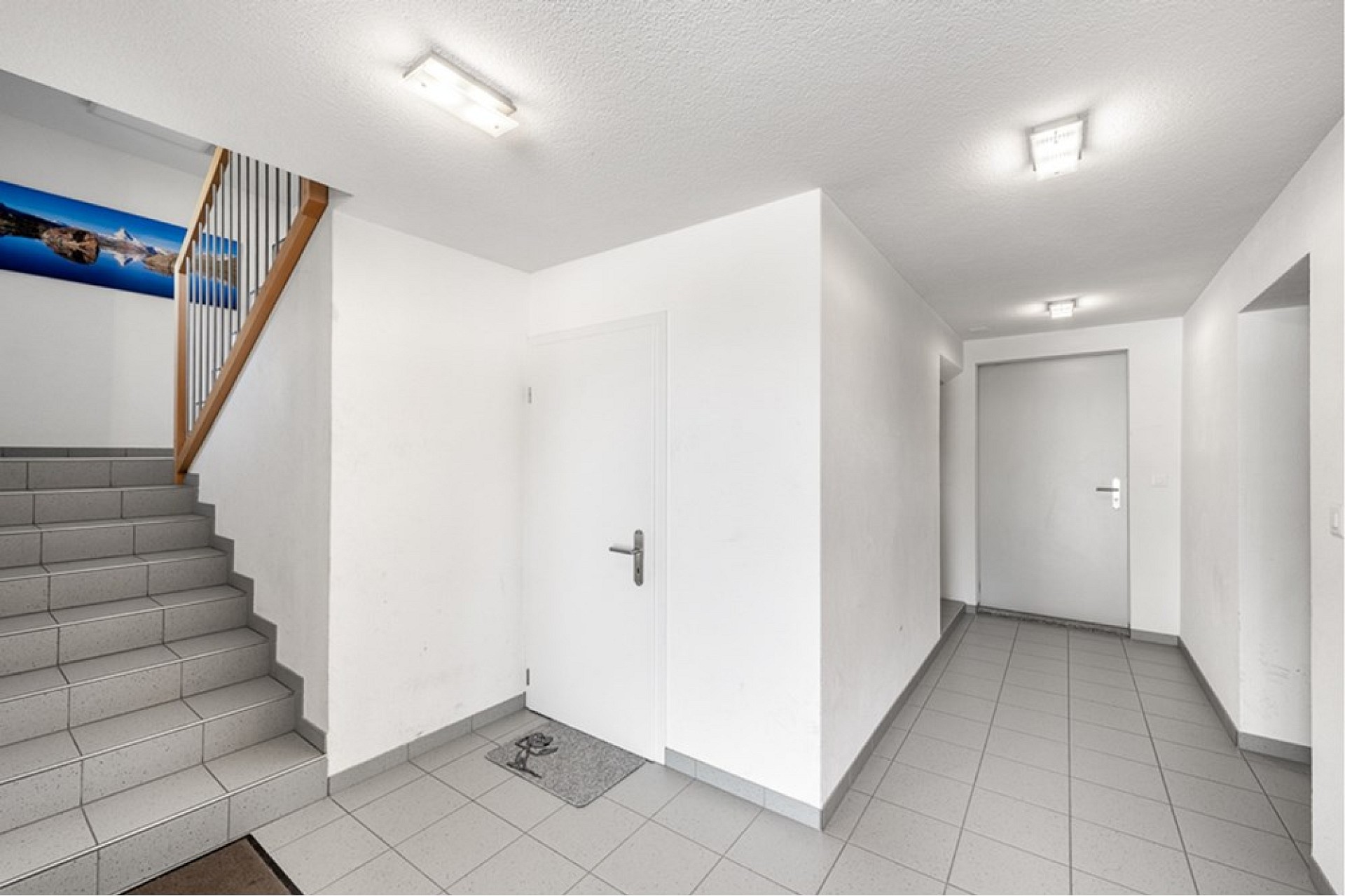 Heller Flur mit Treppe und Türen