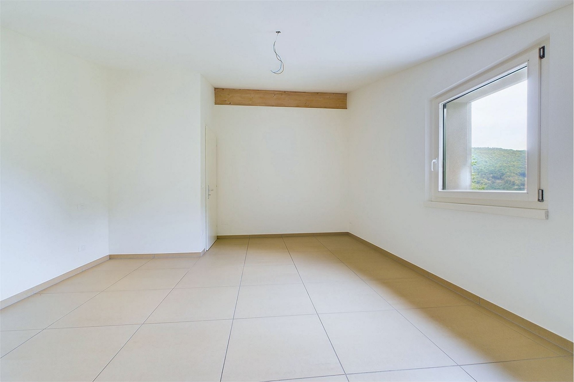 Heller leerer Raum mit Fliesenboden und Fensterblick
