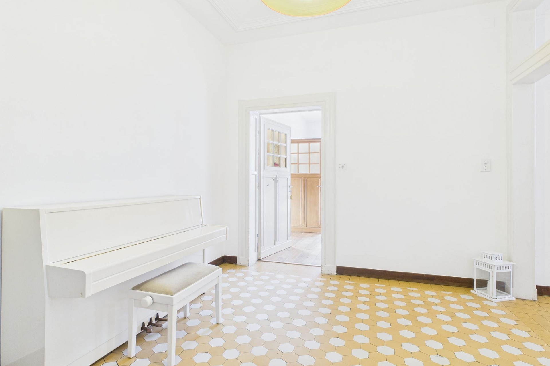 Heller Raum mit weißem Klavier und Fliesenboden