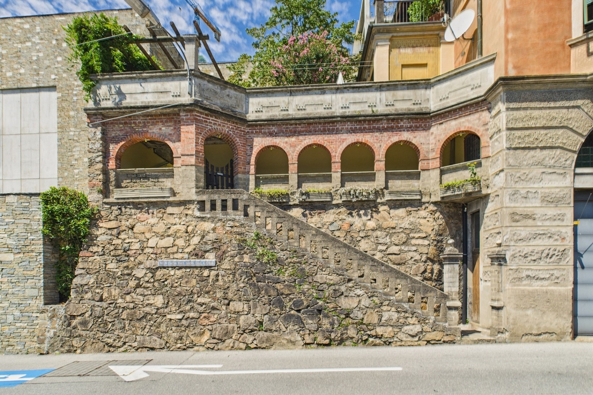 Historische Außenansicht mit Arkaden und Natursteinmauer