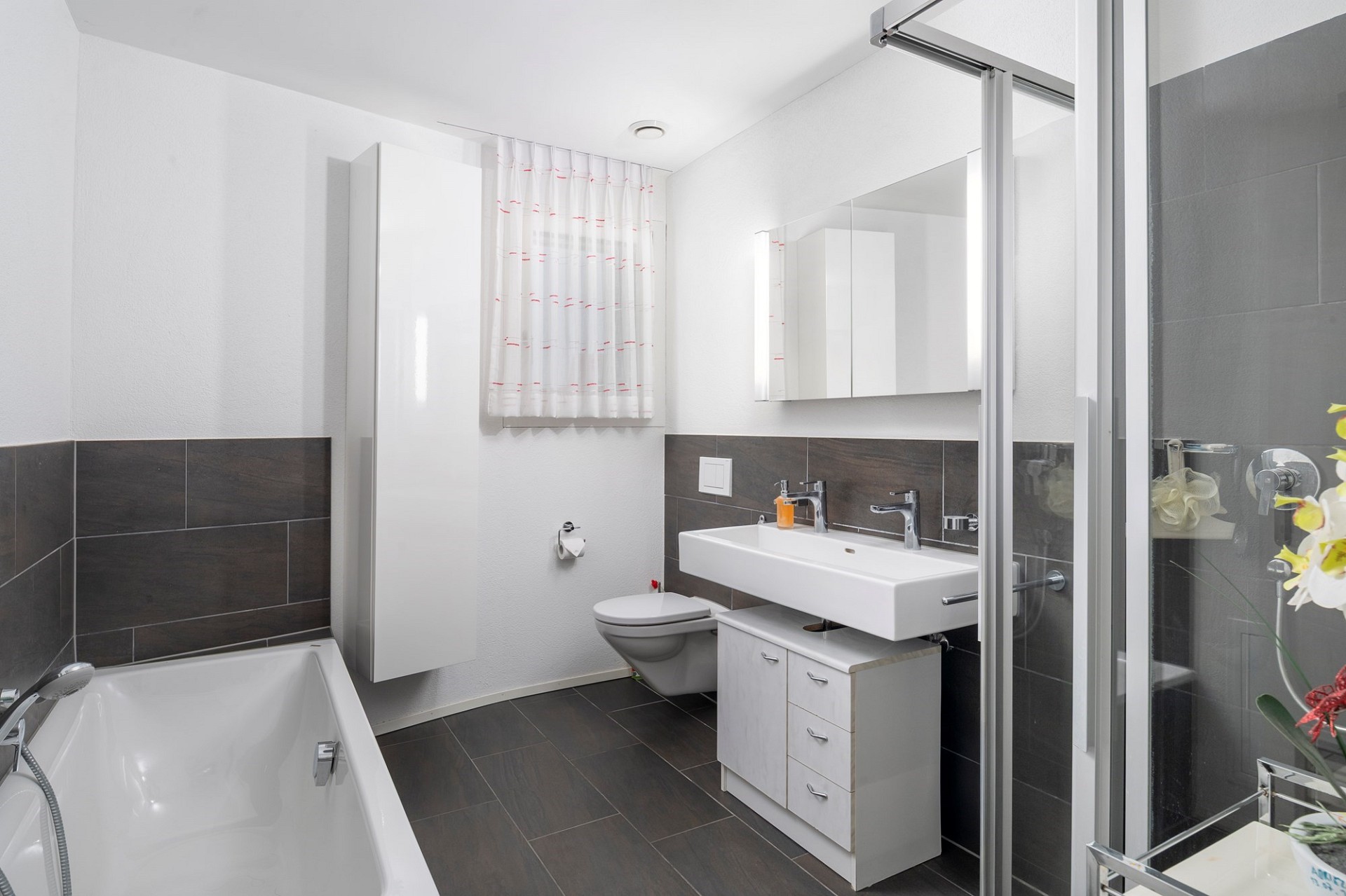 Modernes Badezimmer mit Badewanne und Duschabtrennung