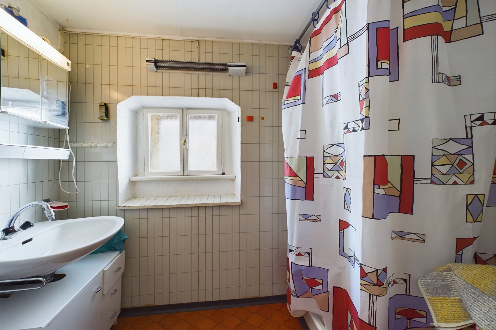 Kleines Badezimmer mit Fenster und Duschvorhang