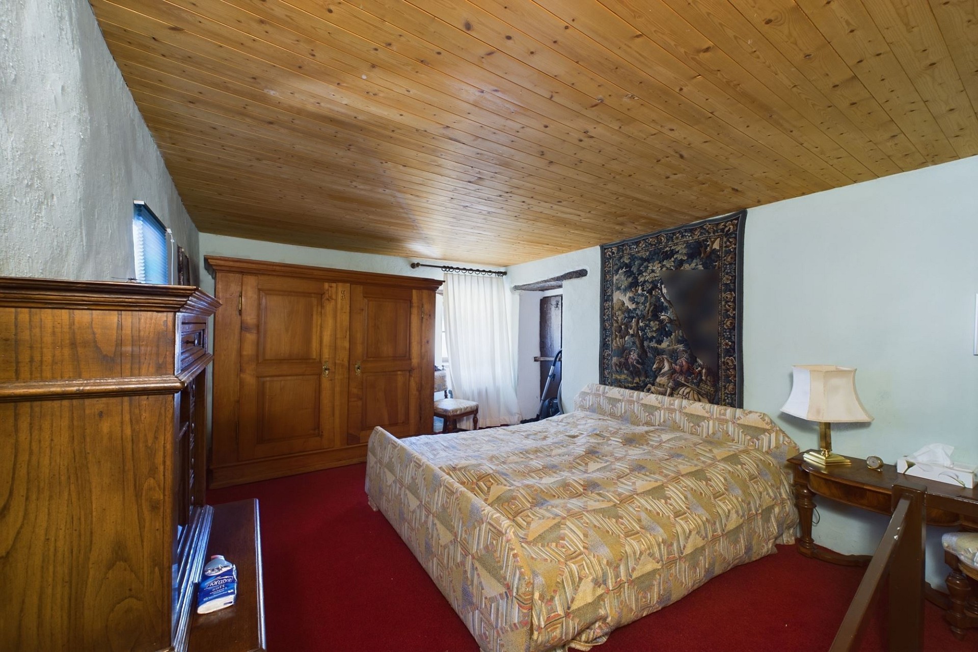 Schlafzimmer mit rustikaler Holzdecke