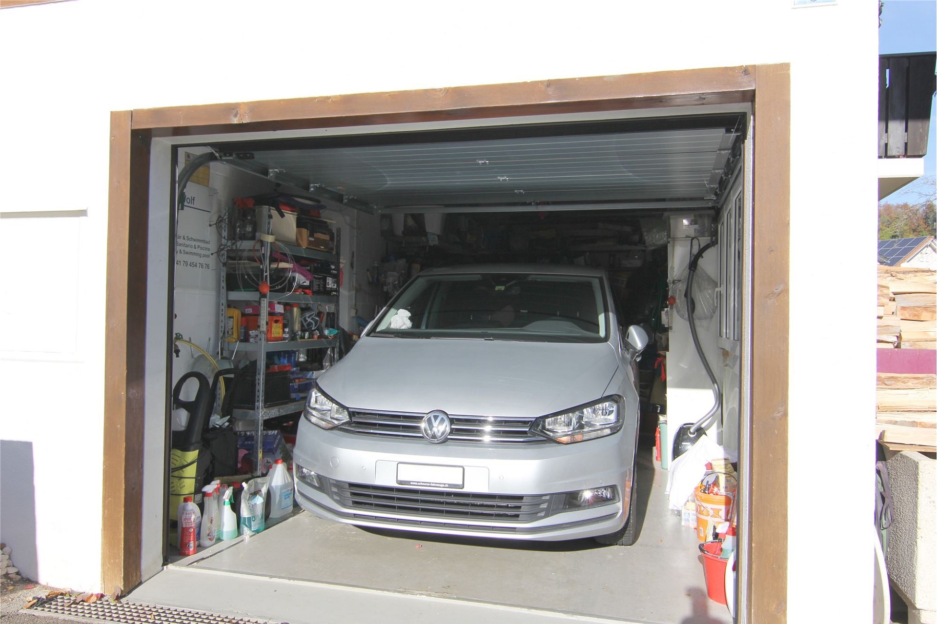 Garage mit geöffnetem Sektionaltor und Auto