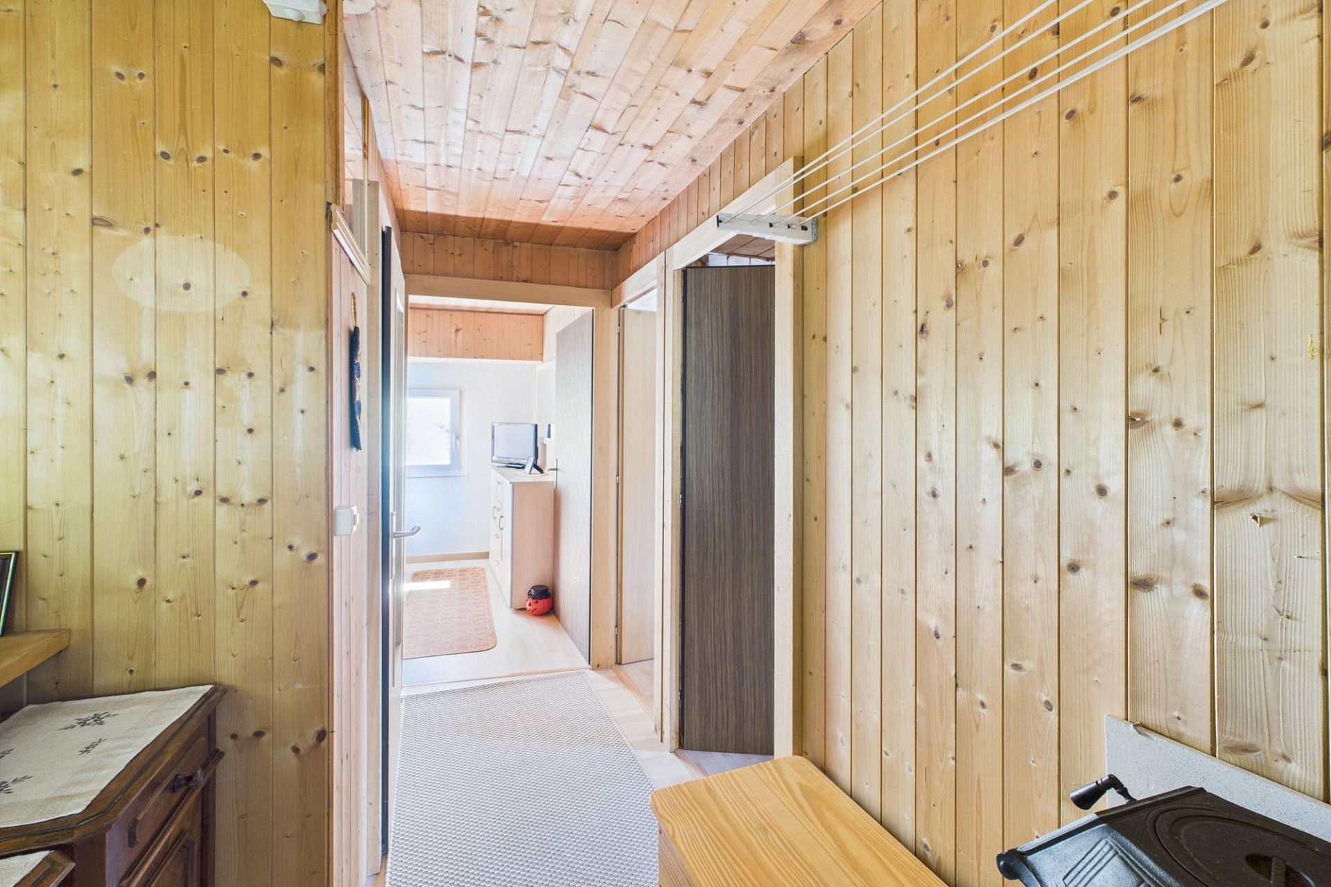 Holzvertäfelter Flur mit Blick in einen hellen Innenbereich