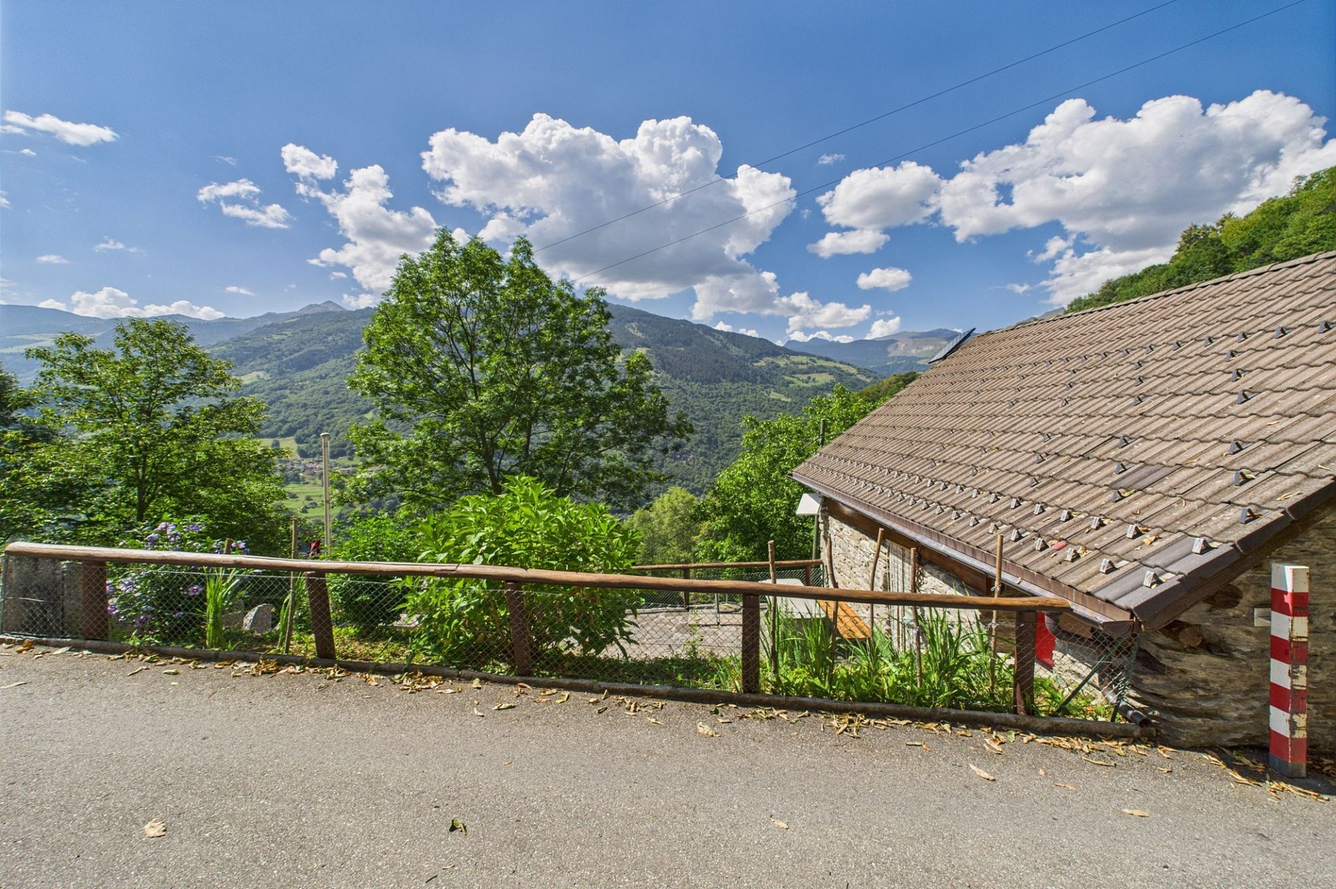 Bergblick mit Hausdach und Hanglage