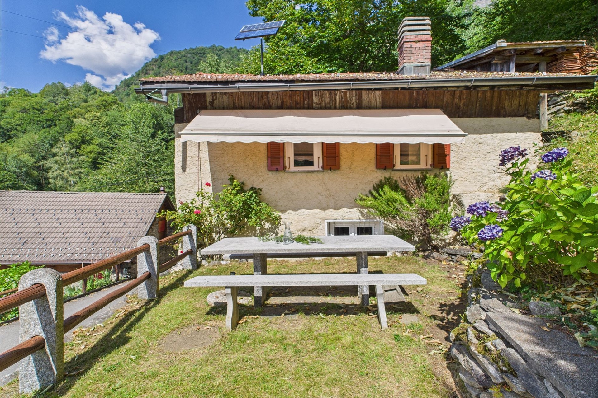 Gartenansicht eines rustikalen Hauses mit Terrasse