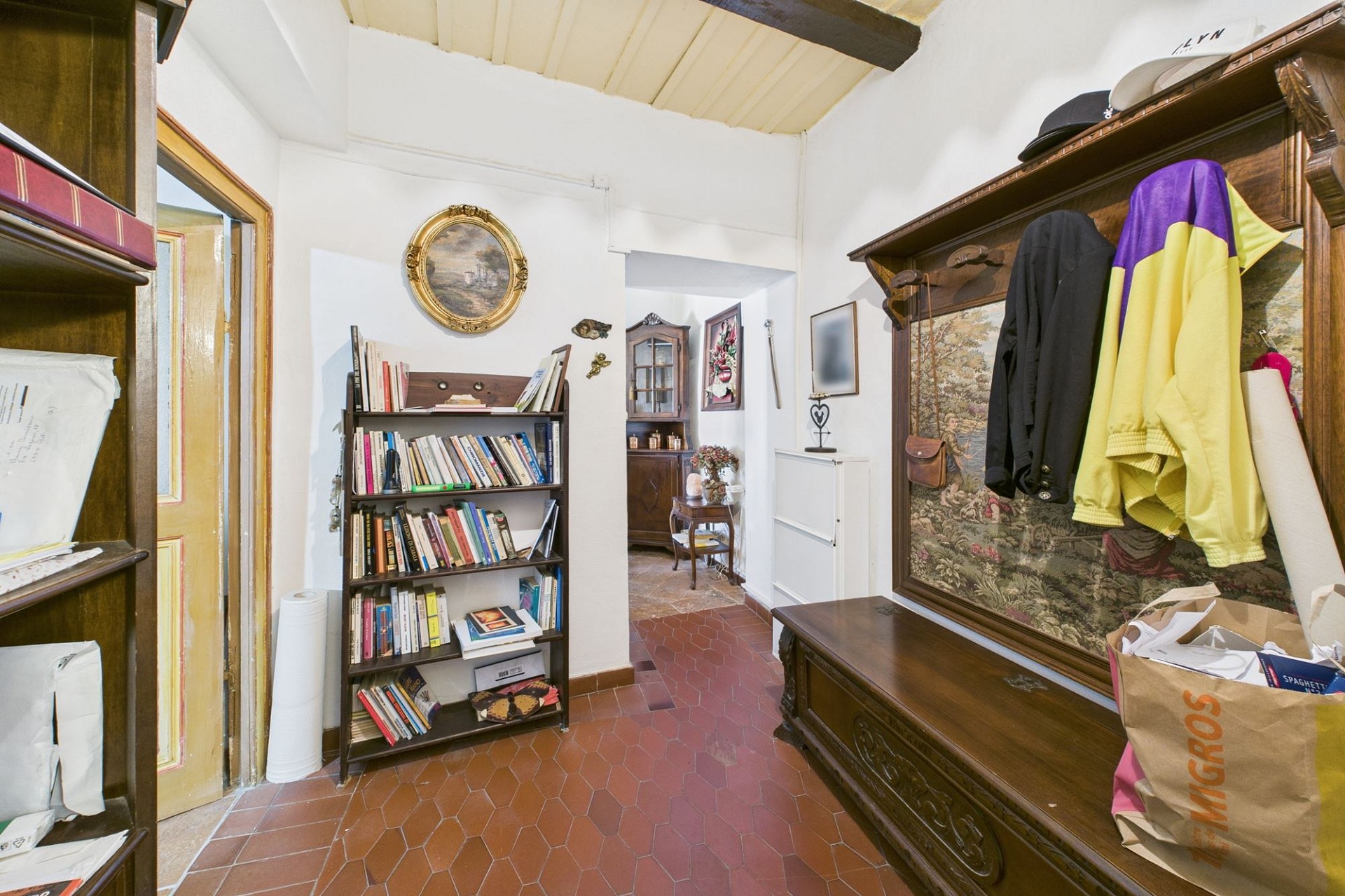 Kleiner historisch eingerichteter Flur mit Bücherregal und Garderobe