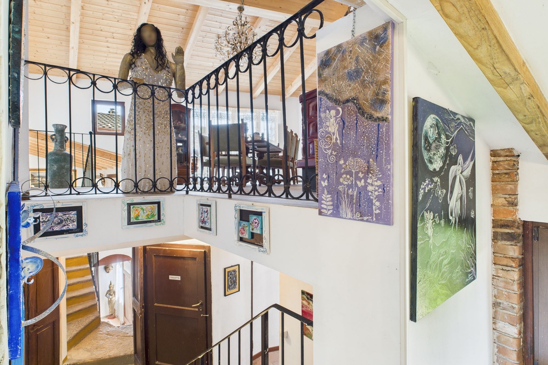 Kunstvoll gestaltetes Treppenhaus mit Galerie