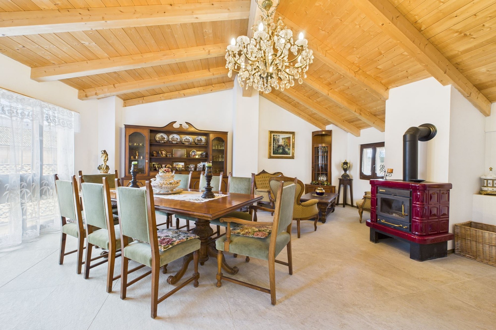 Traditionelles Esszimmer mit Holzdecke und Kaminofen