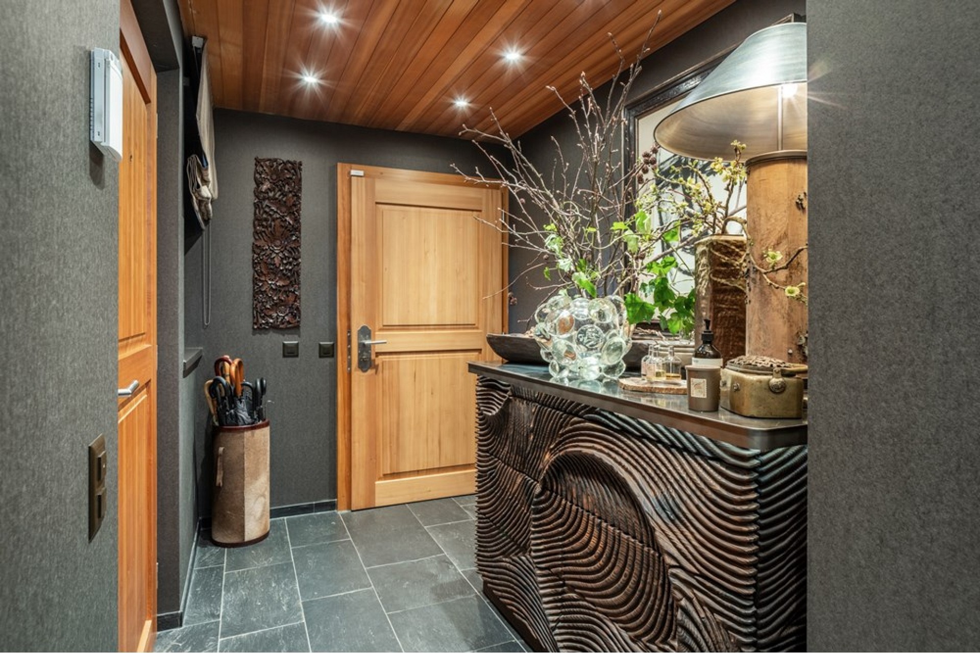 Eleganter Eingangsbereich mit dunklen Wänden und Holzdecke
