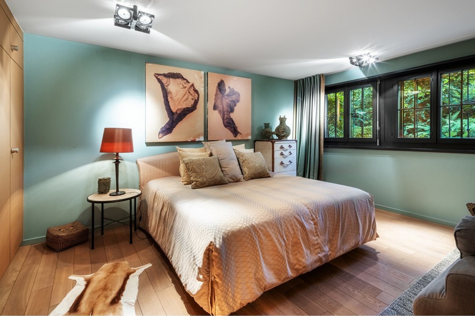 Helles Schlafzimmer mit Naturholz und grüner Wandfarbe