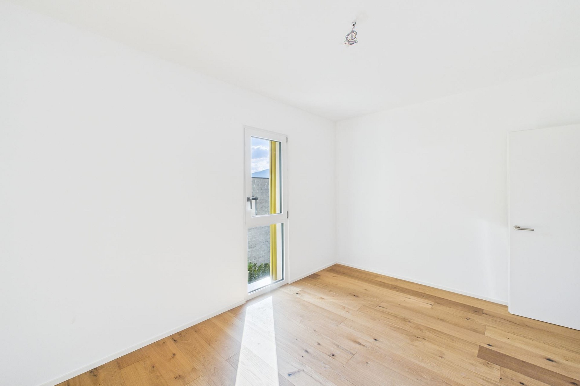 Leeres, helles Zimmer mit Holzboden