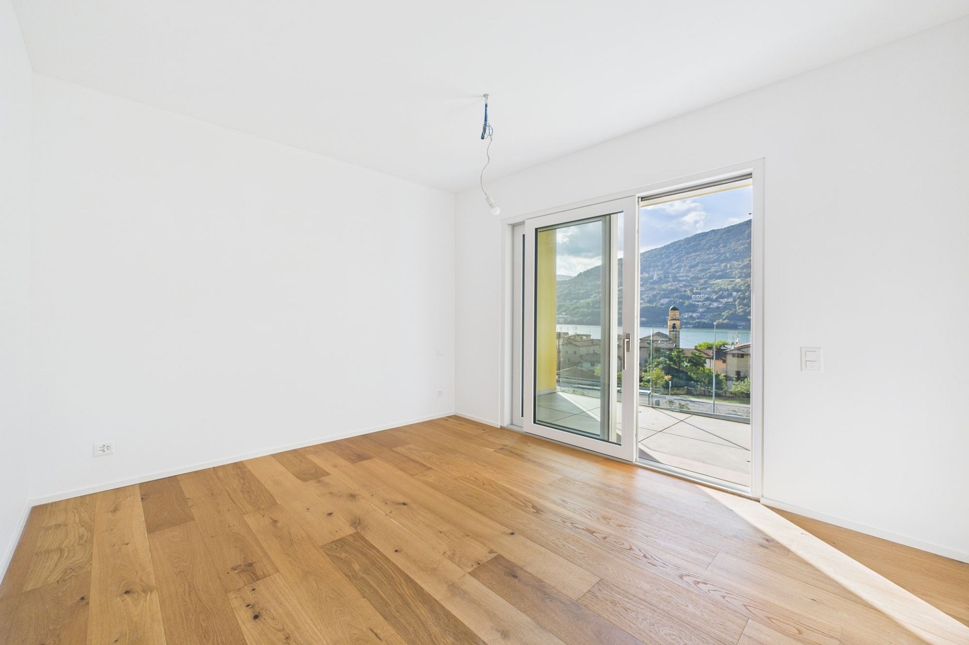 Heller leerer Raum mit Balkon- und Seeblick