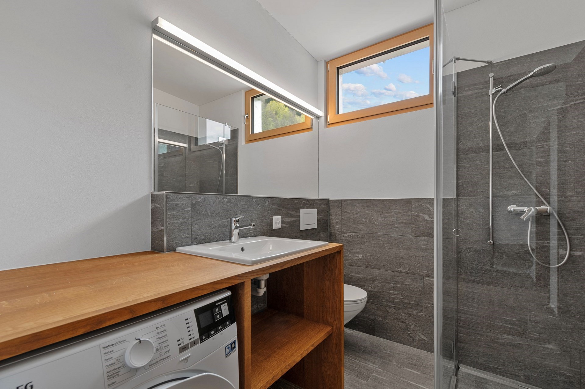 Modernes Badezimmer mit Dusche und Waschplatz