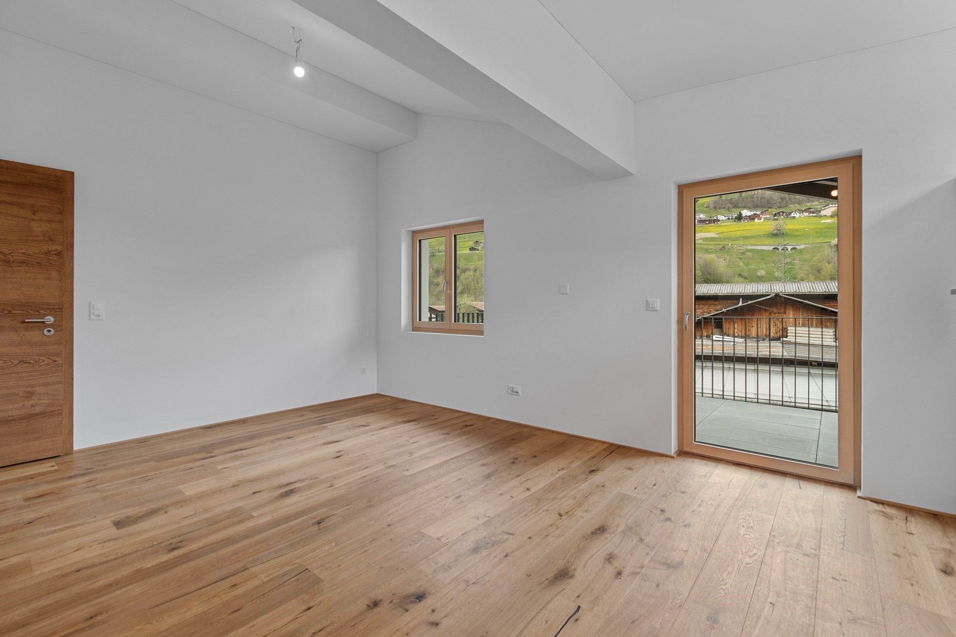 Leerer, modern ausgebauter Raum mit Balkonblick