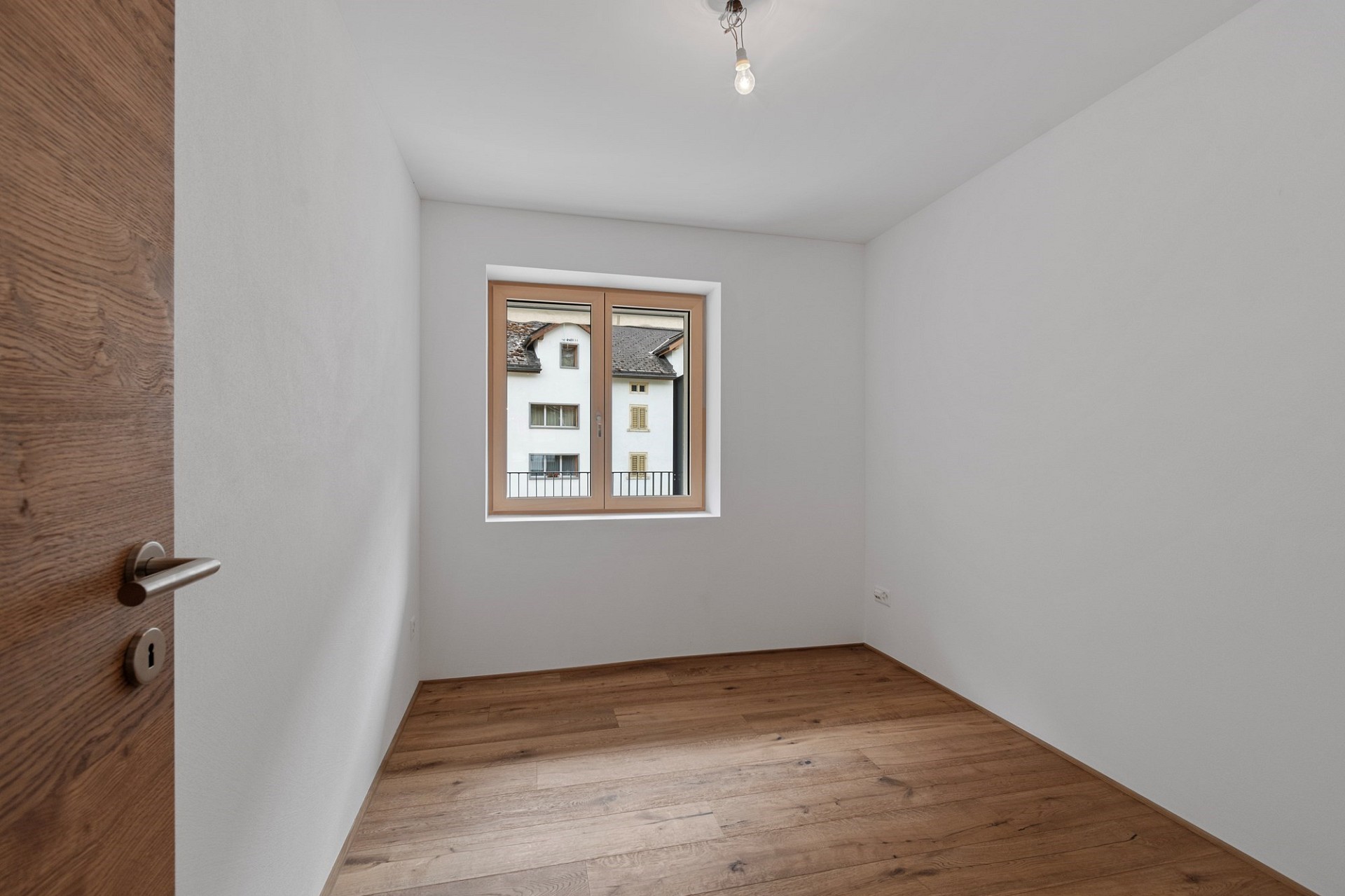 Leerer heller Raum mit Holzfußboden und Fenster