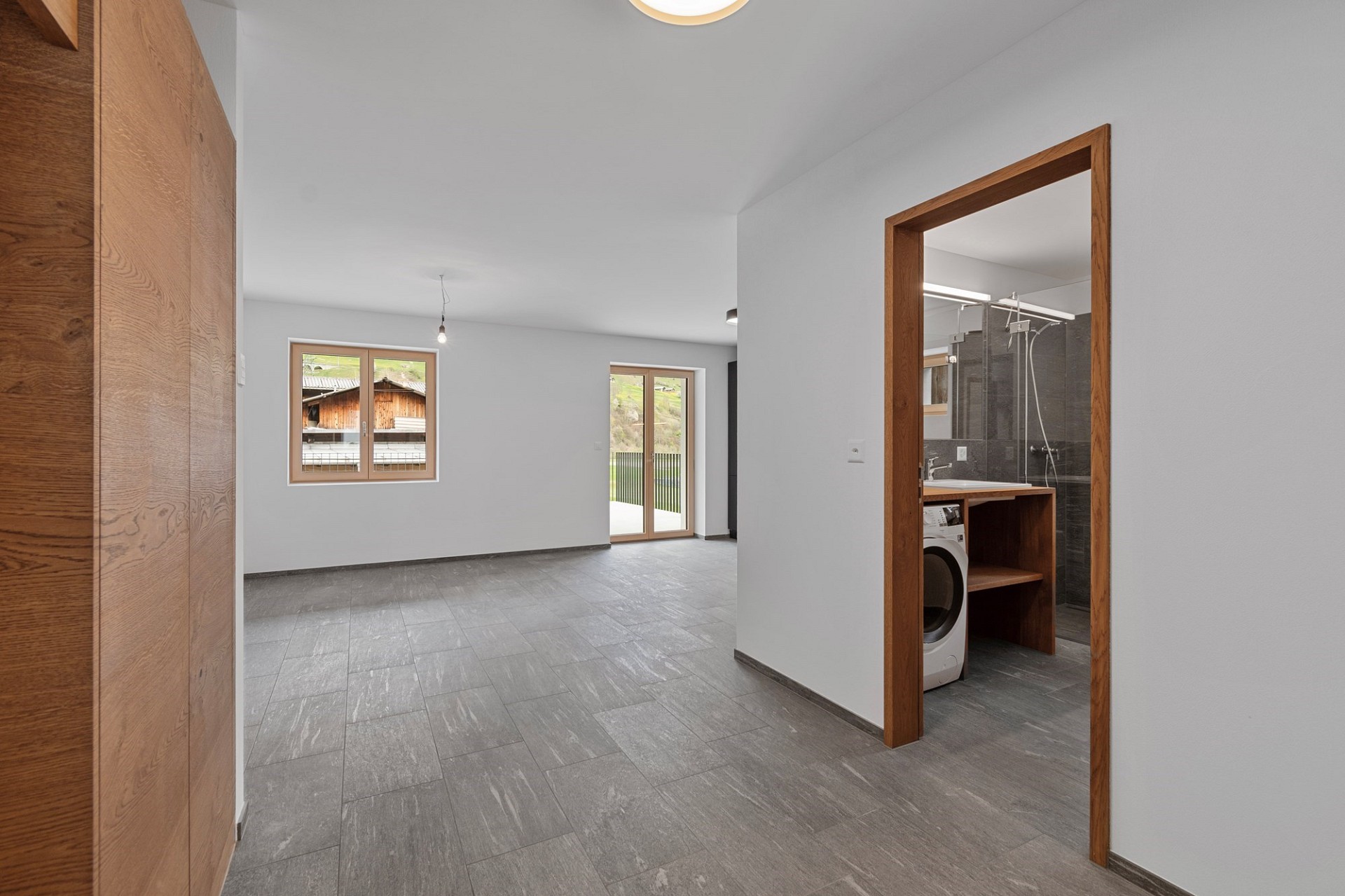 Heller offener Wohnraum mit Blick ins Bad