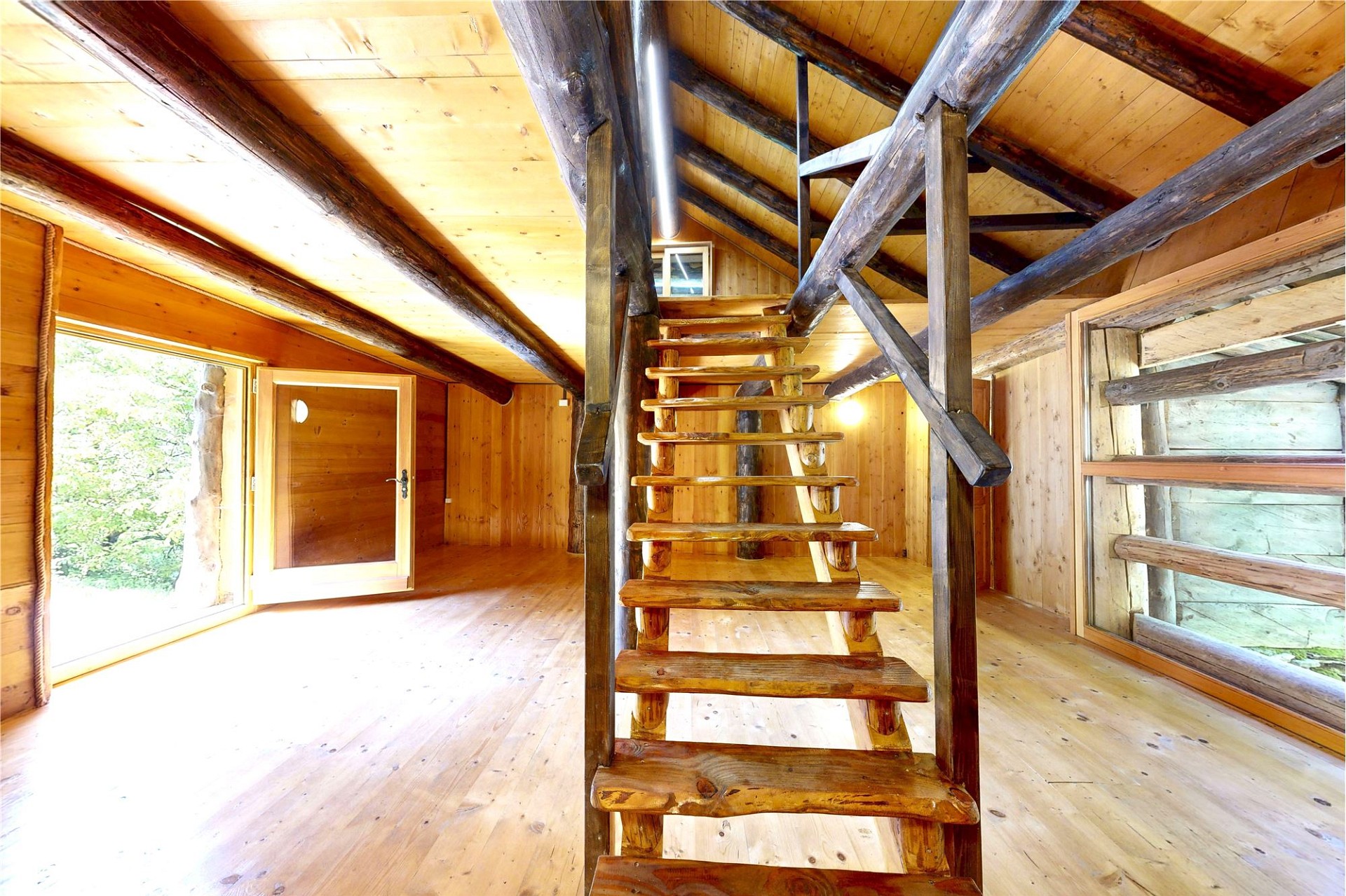 Rustikaler Dachraum mit Holztreppe