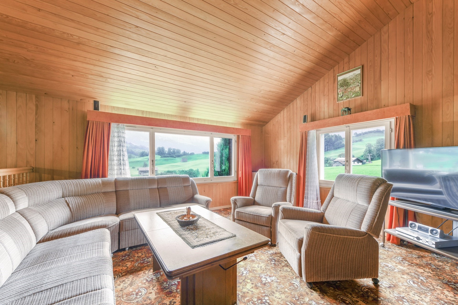 Gemütliches Wohnzimmer mit Holzverkleidung und Panoramablick