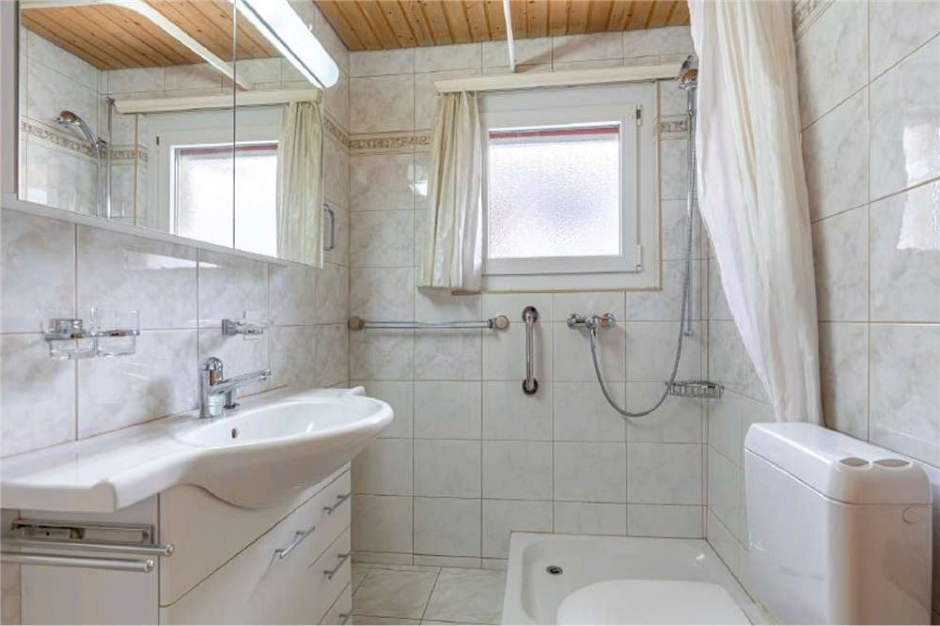 Helles Badezimmer mit Fliesen und Dachfenster