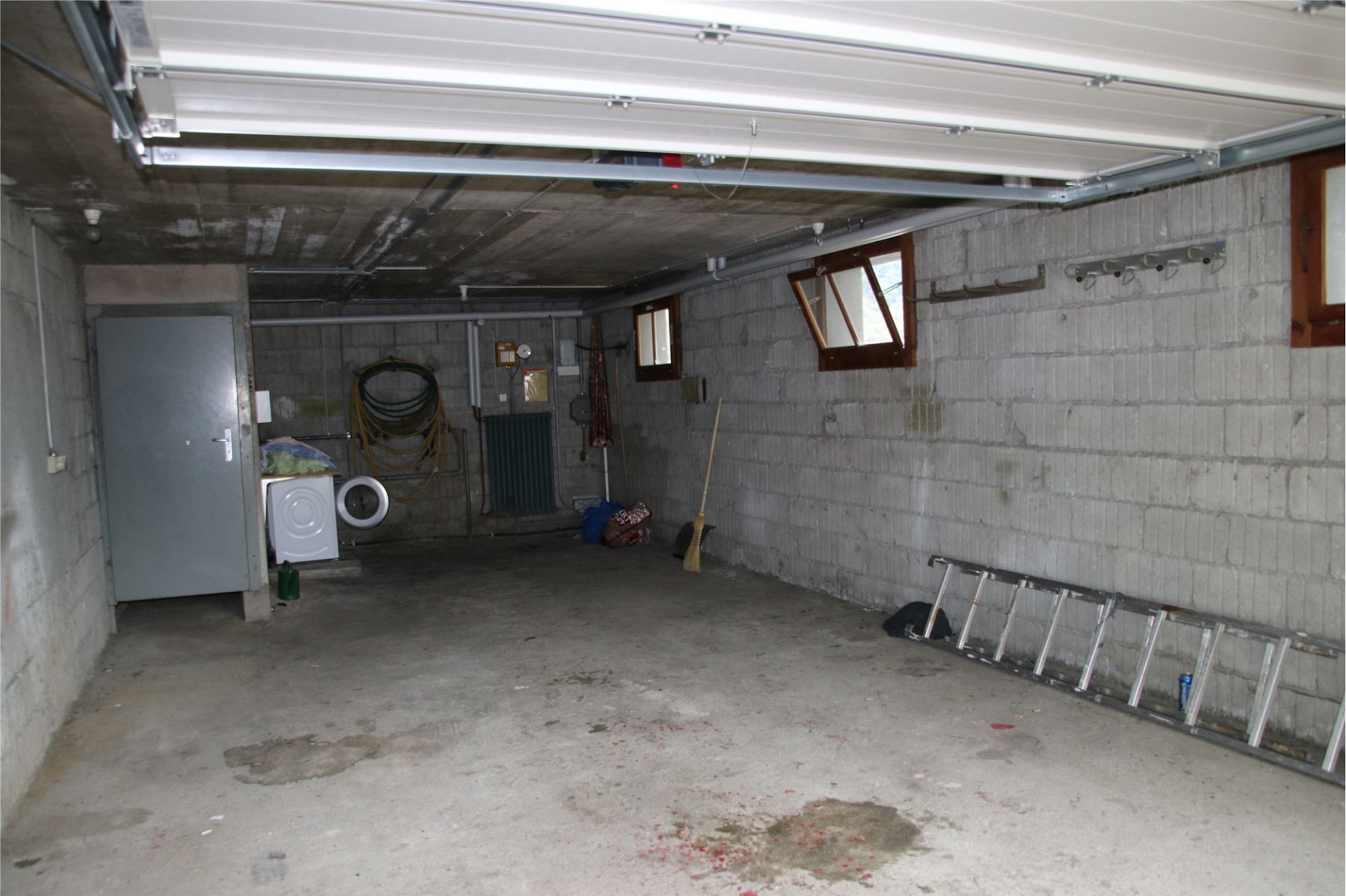 Unordentliche Garage mit Betonwänden und Garagentor