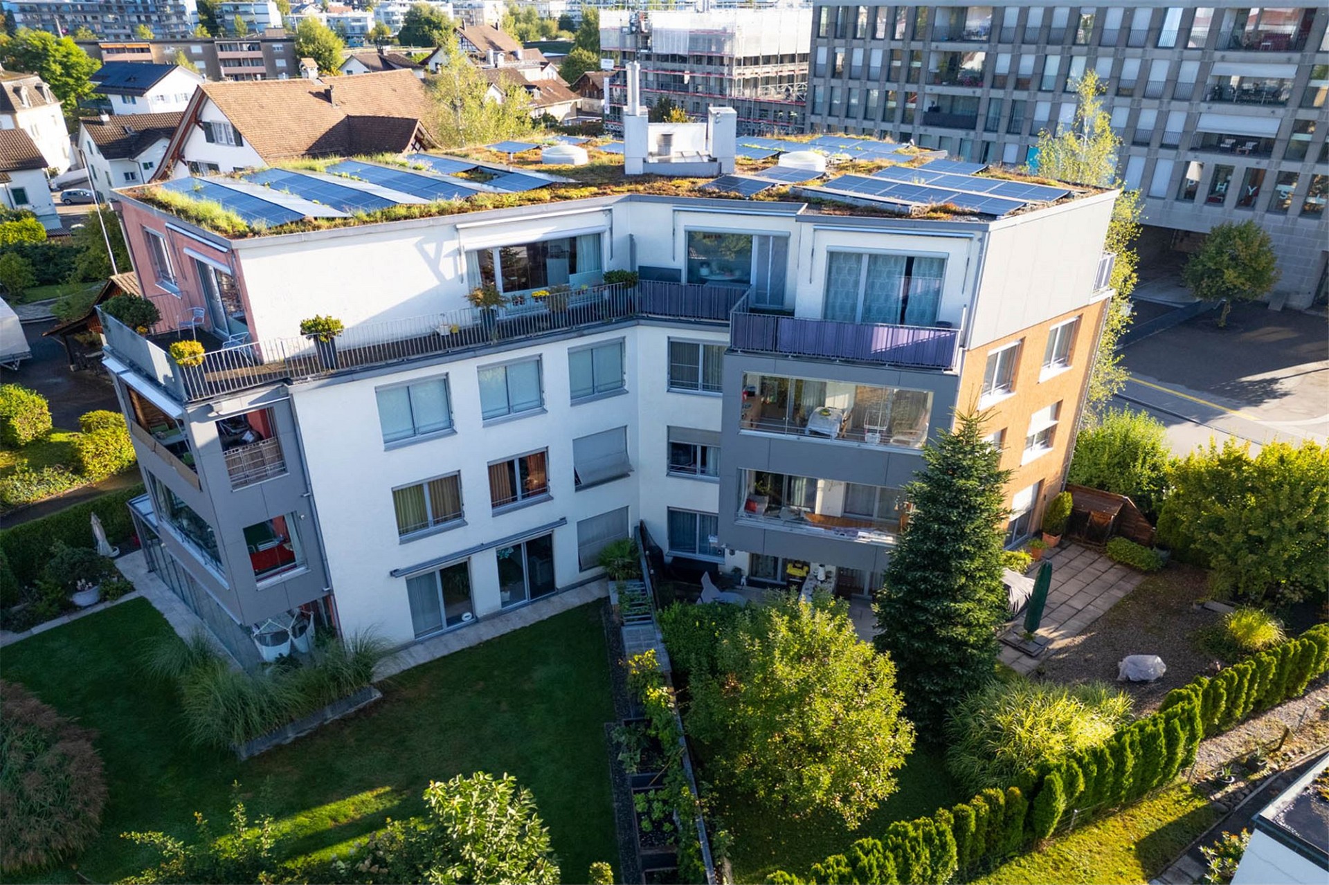Drohnenansicht eines modernen Wohngebäudes mit Gründach und Photovoltaik