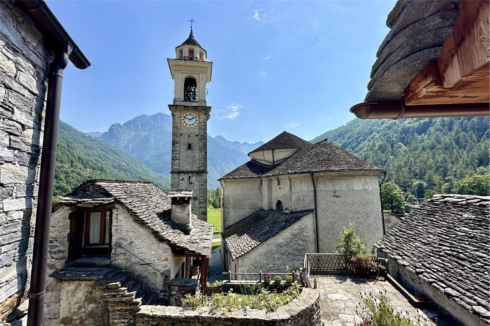 Alpines Dorf mit Kirchturm und Bergpanorama