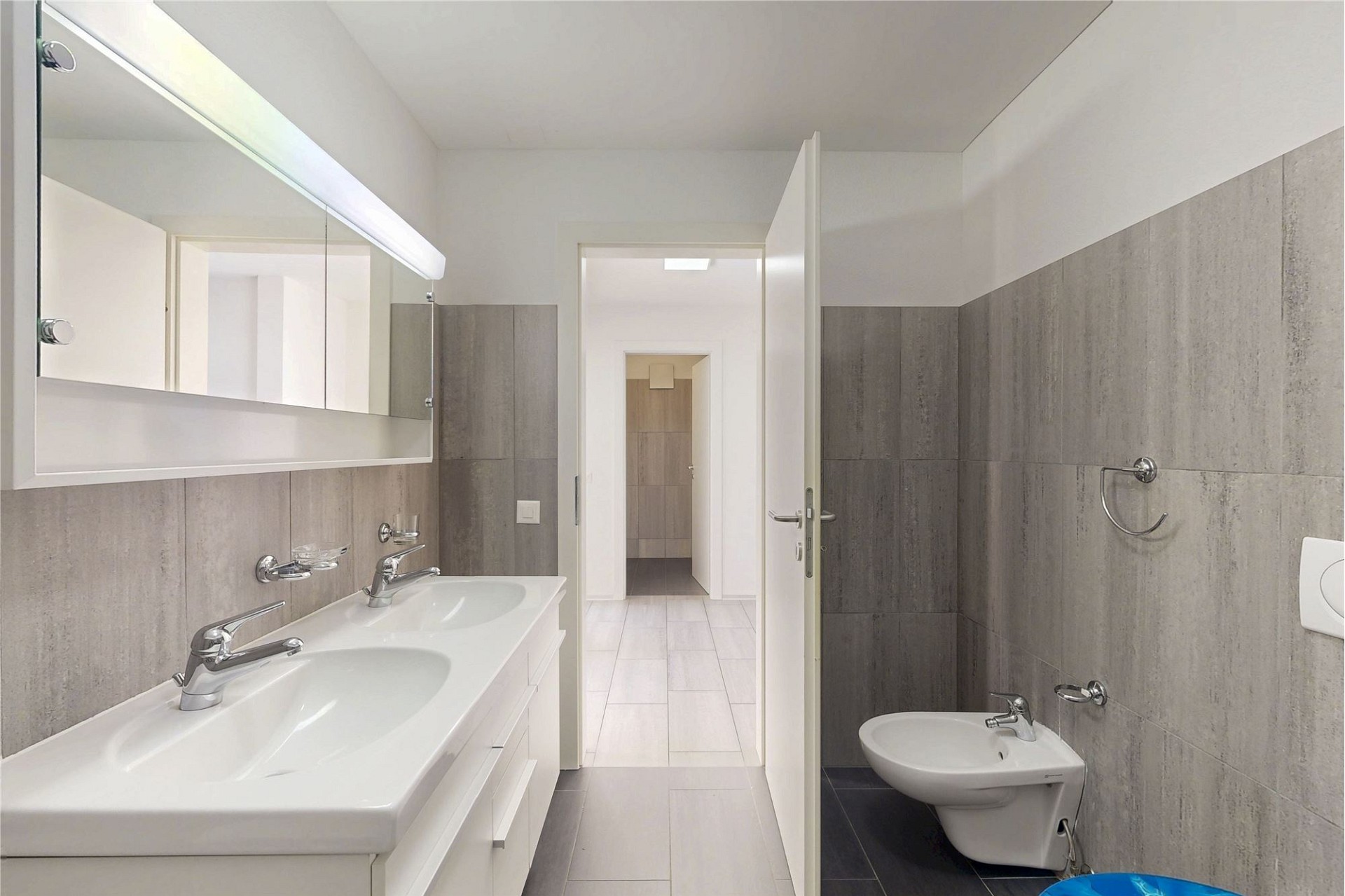 Modernes Badezimmer mit Doppelwaschbecken und separatem WC-Bereich