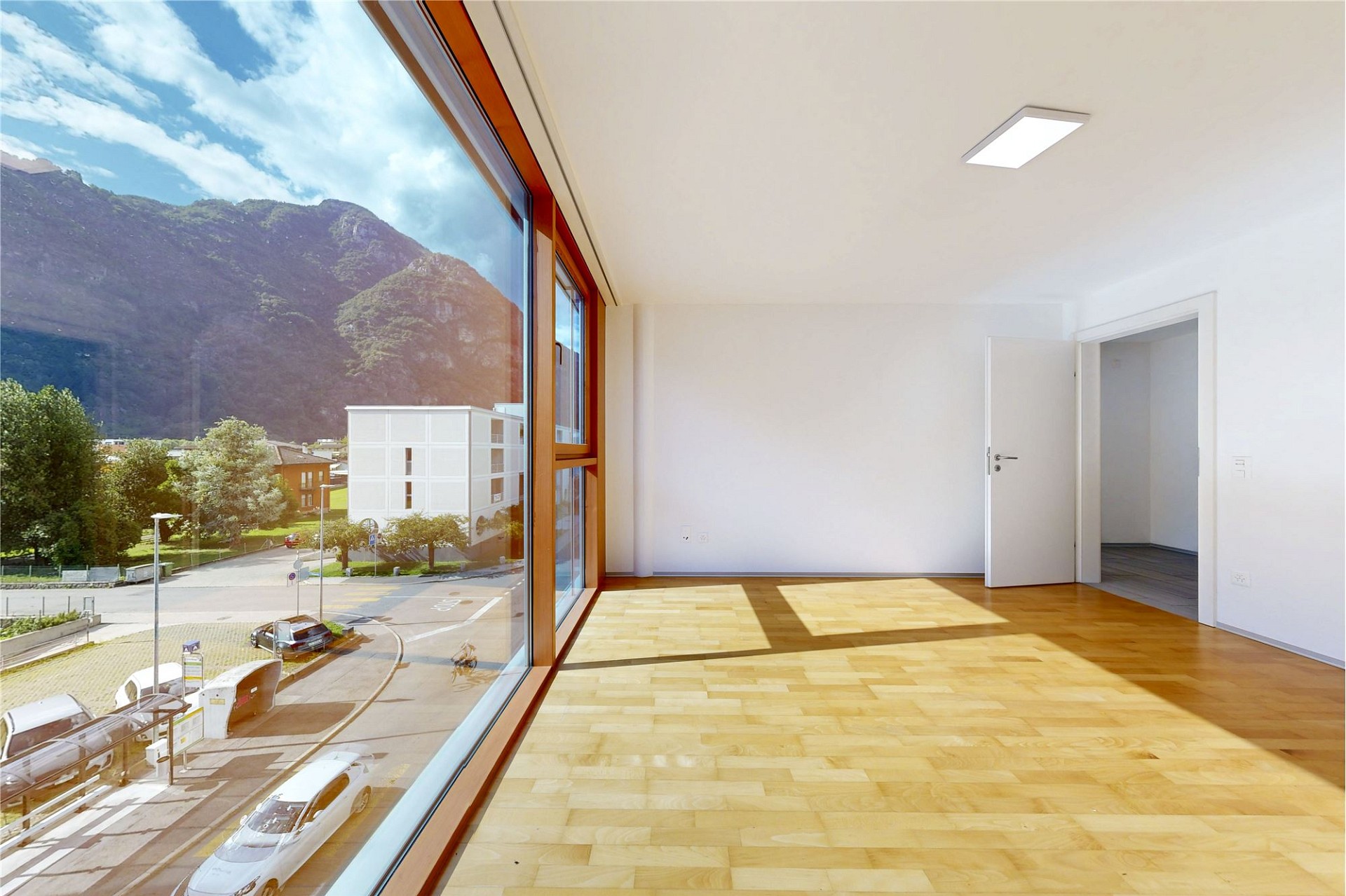 Heller Wohnraum mit Panoramafenster und Bergblick