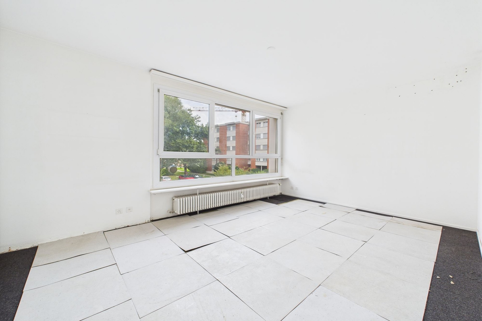 Helles, leeres Zimmer mit großem Fenster