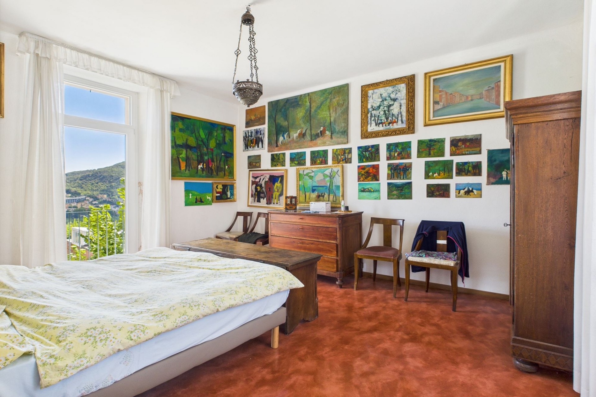 Schlafzimmer mit Balkonblick und vielen Kunstwerken