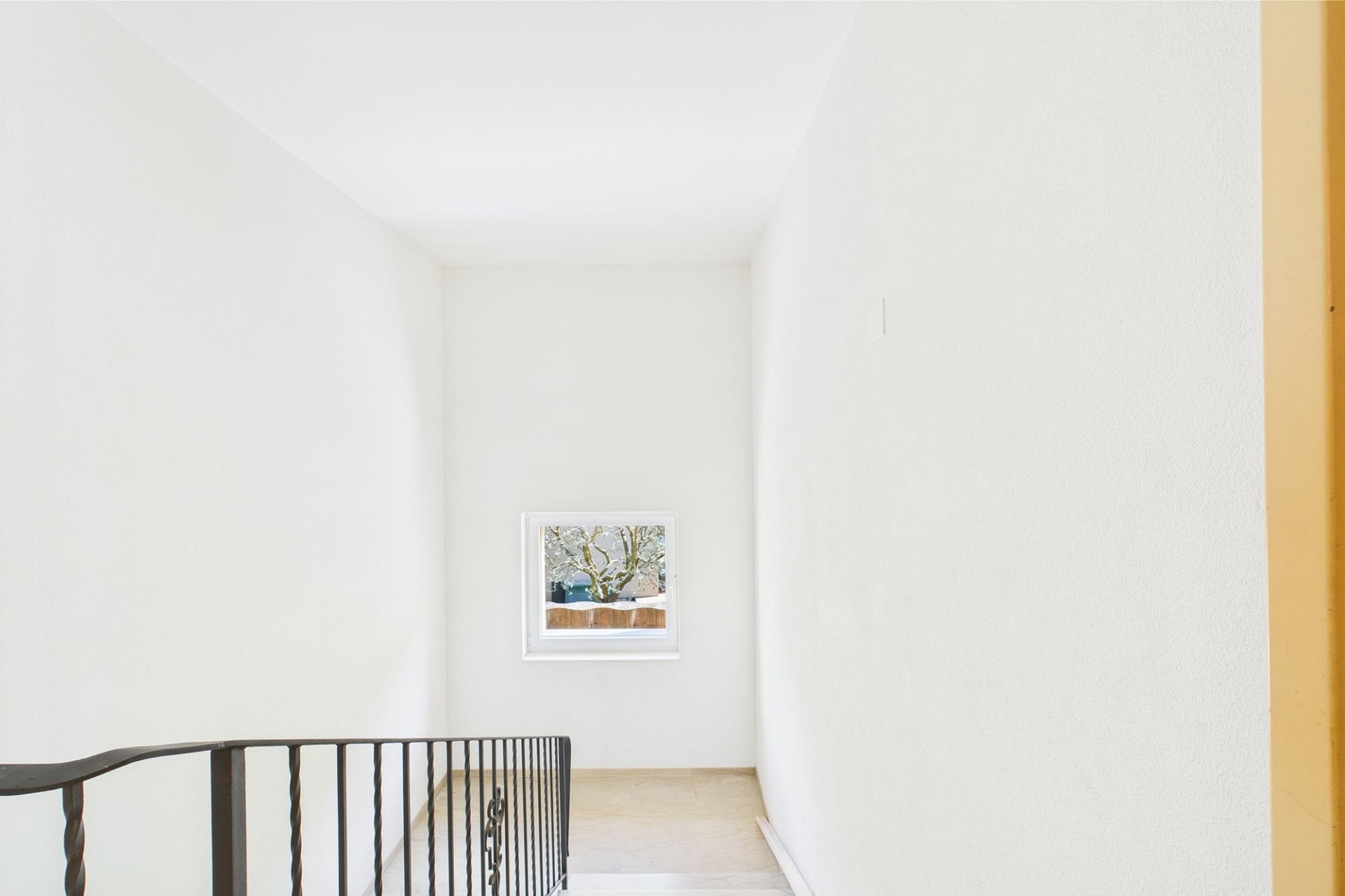 Heller Treppenabsatz mit kleinem Fenster