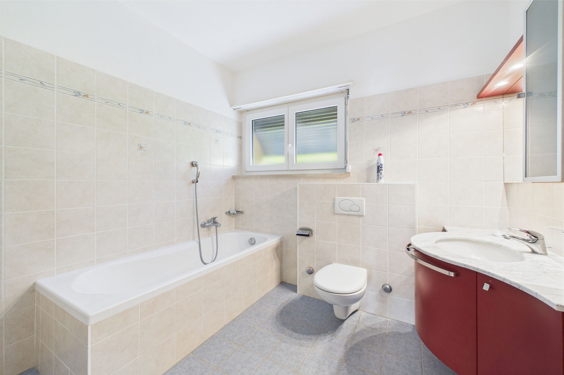 Badezimmer mit Badewanne, WC und Waschbeckenunterschrank