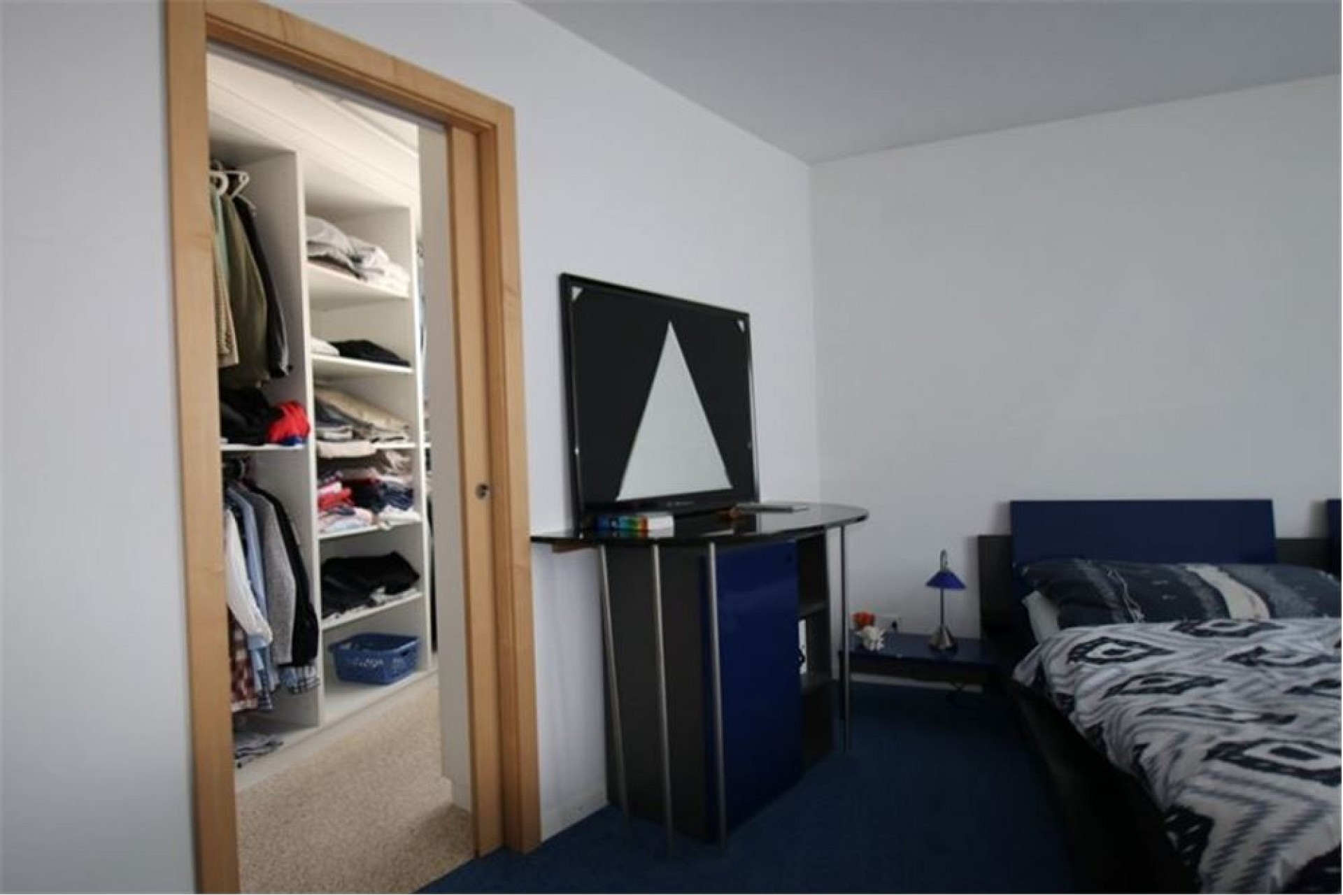 Schlafzimmer mit offenem Kleiderschrank