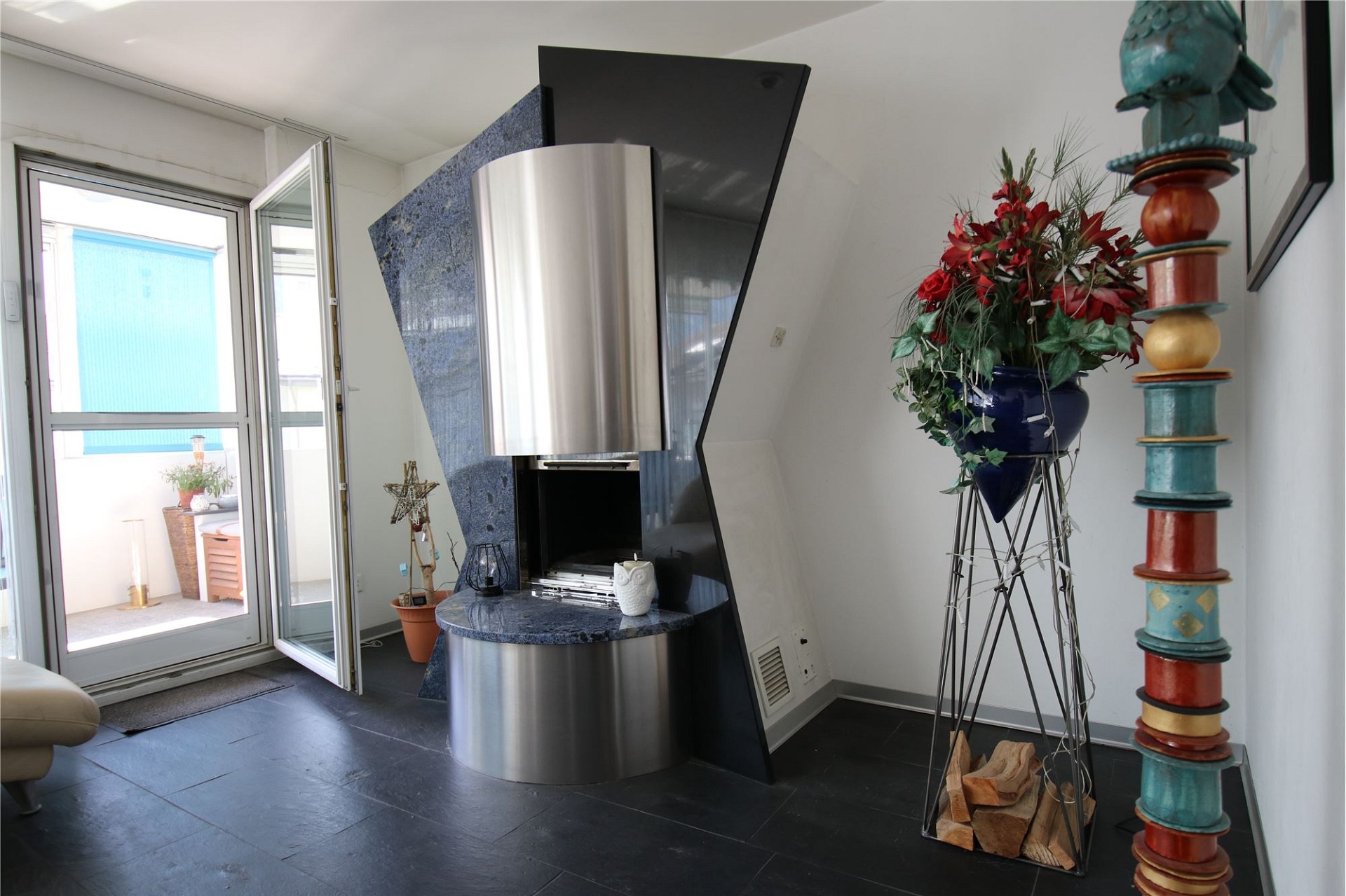 Wohnzimmer mit Kamin und Zugang zur Terrasse