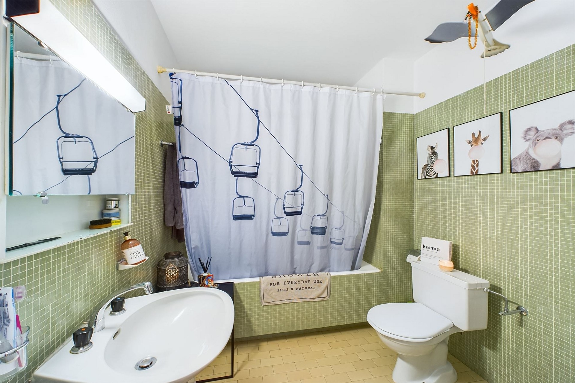 Badezimmer mit grünem Mosaik und Tiermotiven