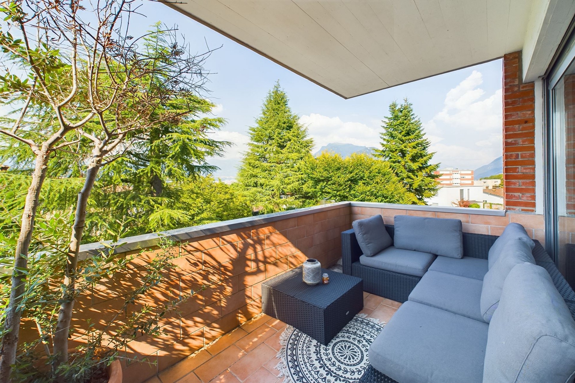 Überdachter Balkon mit Sitzgruppe und Bergblick