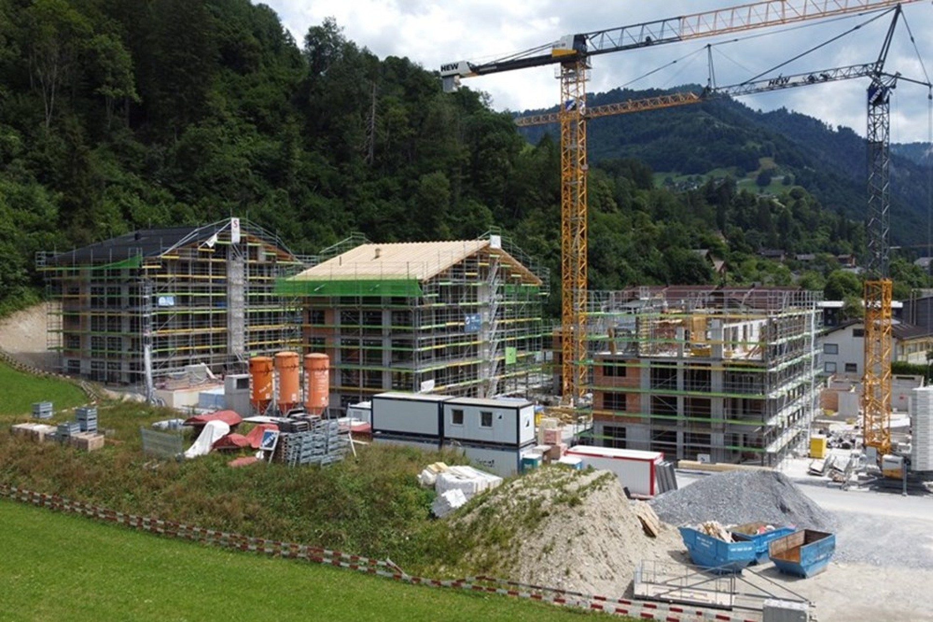 Große Baustelle mit mehreren Wohngebäuden und Kränen
